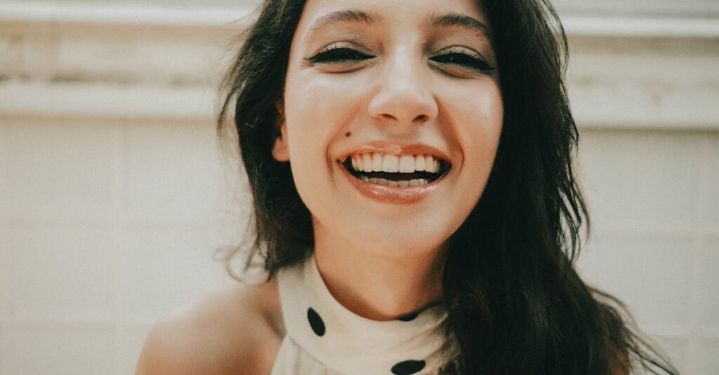 pexels-photo-33669405-33669405 Young woman with a joyful expression and bright smile indoors. Close-up portrait.