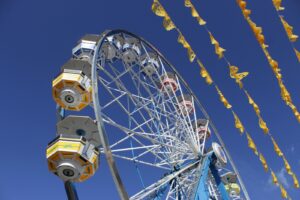 Image of a ferris wheel against a bright blue sky.